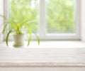 Light wooden table on defocuced summer window background