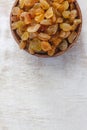 Light yellow raisins in a wooden bowl on a light white background. Close-up. Isolated Royalty Free Stock Photo