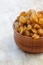 Light yellow raisins in a wooden bowl on a light white background. Close-up. Isolated Royalty Free Stock Photo