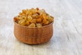 Light yellow raisins in a wooden bowl on a light white background. Close-up. Isolated Royalty Free Stock Photo