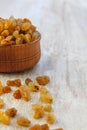 Light yellow raisins in a wooden bowl on a light white background. Close-up. Isolated Royalty Free Stock Photo