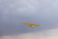 Light yellow turboprop aircraft flies across the sky among the clouds Royalty Free Stock Photo