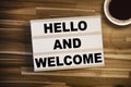 Lightbox or light box with message Hello and welcome on a wooden table