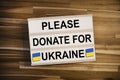 Lightbox or light box with message please donate for ukraine on wooden table background