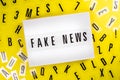 Lightbox with message FAKE NEWS on yellow background letters aroung, big lie