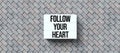 Lightbox with message FOLLOW YOUR HEART on stone background - 3D rendered illustration