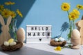 Lightbox with message HELLO MARCH on festive blue background and eco-friendly zero waste natural decoration. Yellow Royalty Free Stock Photo