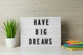 Lightbox with motivational quote Have Big Dreams, stationery and plant on white wooden table