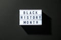 Lightbox with text BLACK HISTORY MONTH on dark black background. Message historical event