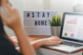 Lightbox with text hashtag STAYHOME glowing in lightand blurred woman working at home. Office worker on quarantine. Home working