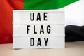 Lightbox with text UAE FLAG DAY on United Arab Emirates waving flag made from silk material. Independence Commemoration Royalty Free Stock Photo