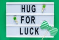 Lightbox with title Hug for luck on green background. Creative background to St. Patricks Day. Flat lay composition