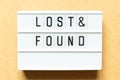 Light box with word lost & found on wood background