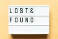 Light box with word lost & found on wood background