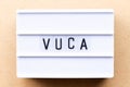 Lightbox with word VUCA abbreviation of Volatility, uncertainty, complexity and ambiguity on wood background Royalty Free Stock Photo