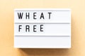 Lightbox with word wheat free on wood background