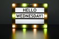 Lightbox with yellow and orange lights in dark room with words - Hello Wednesday