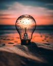 Lightbulb idea with water drops at sunrise on the beach of Barcelona, Catalunya, Spain with sand dunes