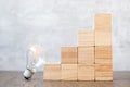 Lightbulb and wood block stack of building with business idea, creative, thinking goal, strategy and innovation concept Royalty Free Stock Photo