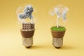 lightbulbs with minature wind turbine and coal-fired power station inside green soil and clouds pollution and smoke renewable