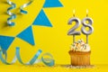 Birthday candle number 28 with cupcake - Yellow background with blue pennants