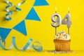 Lighted birthday candle number 94 - Yellow background with blue pennants