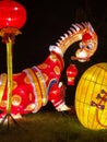 Lighted brown dinosaur display at China Lights show in Hales Corner, Wisconsin with hanging red Chinese lanterns