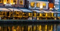 Lighted buildings with terraces at night, beautiful water scenery in the city of Alphen aan den Rijn, The netherlands