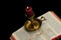 Lighted candle on open Bible