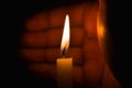 A lighted candle protected against the wind by a hand Royalty Free Stock Photo