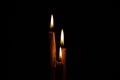 Lighted candle stands in a dark room close-up Royalty Free Stock Photo