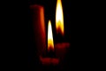 Lighted candle stands in a dark room close-up Royalty Free Stock Photo