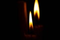 Lighted candle stands in a dark room close-up Royalty Free Stock Photo