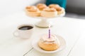 Lighted candle on a sweet pastry to make a birthday wish