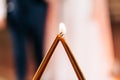 Lighted decorative golden candles touching each other on the background of brides