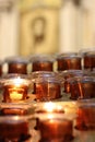 Lighted devotion candles in an orange glass jar Royalty Free Stock Photo