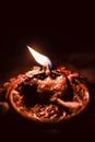 A lighted diwali diya with black background