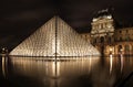 Lighted glass pyramid and Louvre Palace