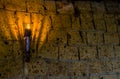 Lighted medieval castle torch hanging on a stone wall, vintage objects and background