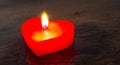 Lighted red candle in the form of a heart on a dark wooden background. Free space for text_ Royalty Free Stock Photo