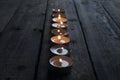 Lighted small candles laid out in a row on a wooden table. Texture. Symbol. Holidays love day