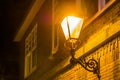 Lighted street lantern on the wall of a house at night, city scenery in the evening, vintage decoration Royalty Free Stock Photo