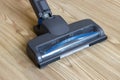 Lighted vacuum cleaner head on parquet floor Royalty Free Stock Photo