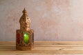 Lightened lantern on wooden table over stone wall background. Ramadan kareem holiday celebration concept