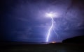 Lightening storm moving in over beach, with city.