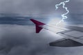 Lightening strikes aircraft wing of airplane on dark sky