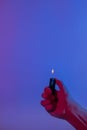 Lighter in a man`s hand. Neon colors in the photo. A pink to blue gradient in the background Royalty Free Stock Photo