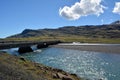 A lighthouse against the background of the Snowy peaks of the basaltic mountains of the eastern fjords in Iceland