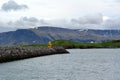 A lighthouse against the background of the Snowy peaks of the basaltic mountains of the eastern fjords in Iceland