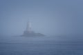 Lighthouse Along Rocky Coastline on Foggy Morning Royalty Free Stock Photo